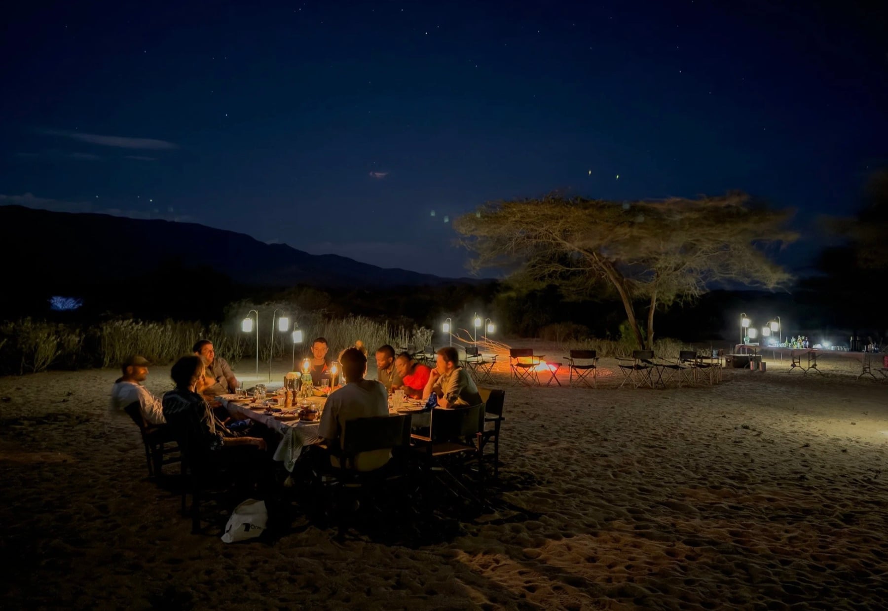 Lantern-lit dinner under the stars at a private camp