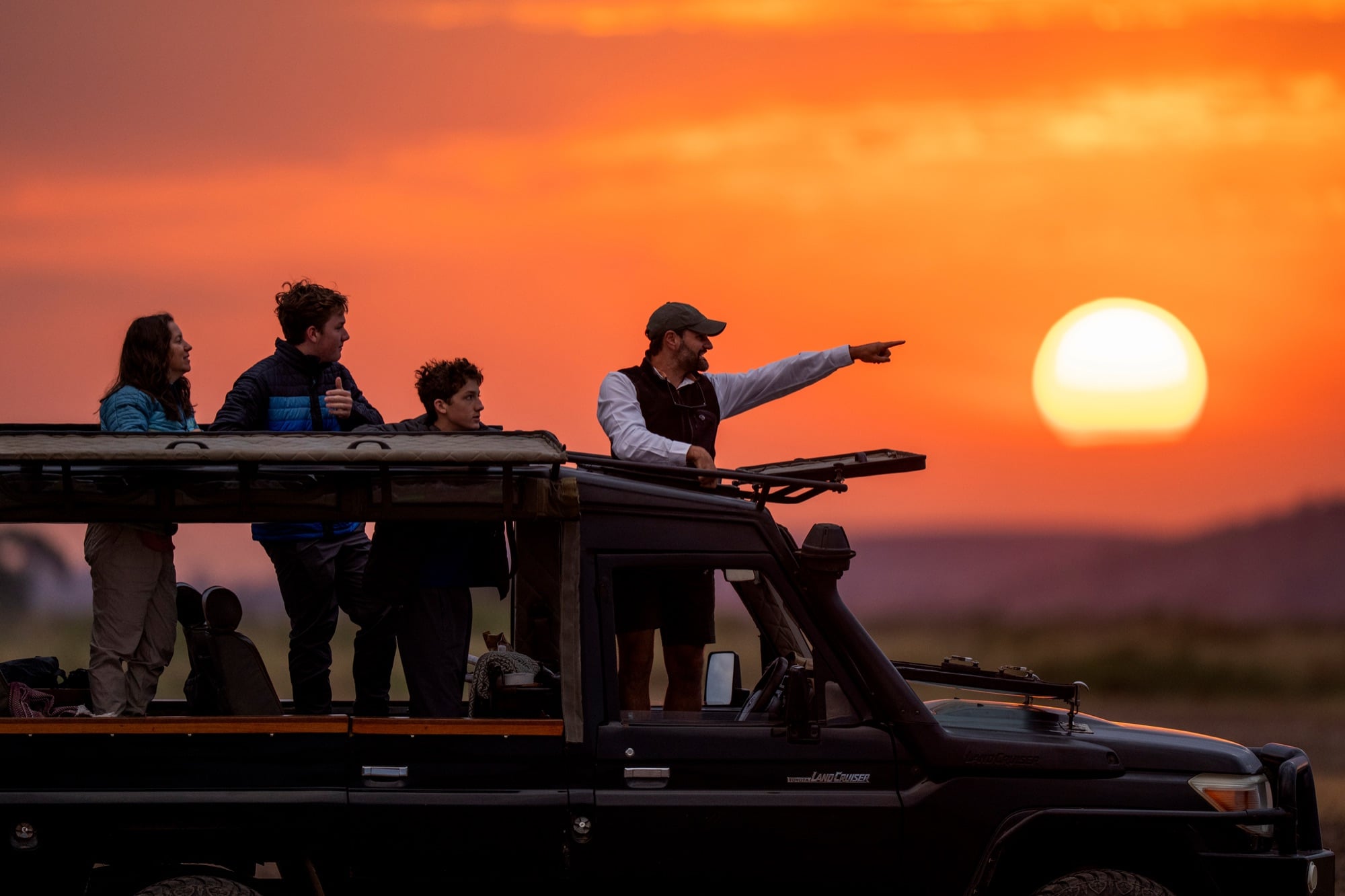 Guests and guide watching the sunset from the cruiser