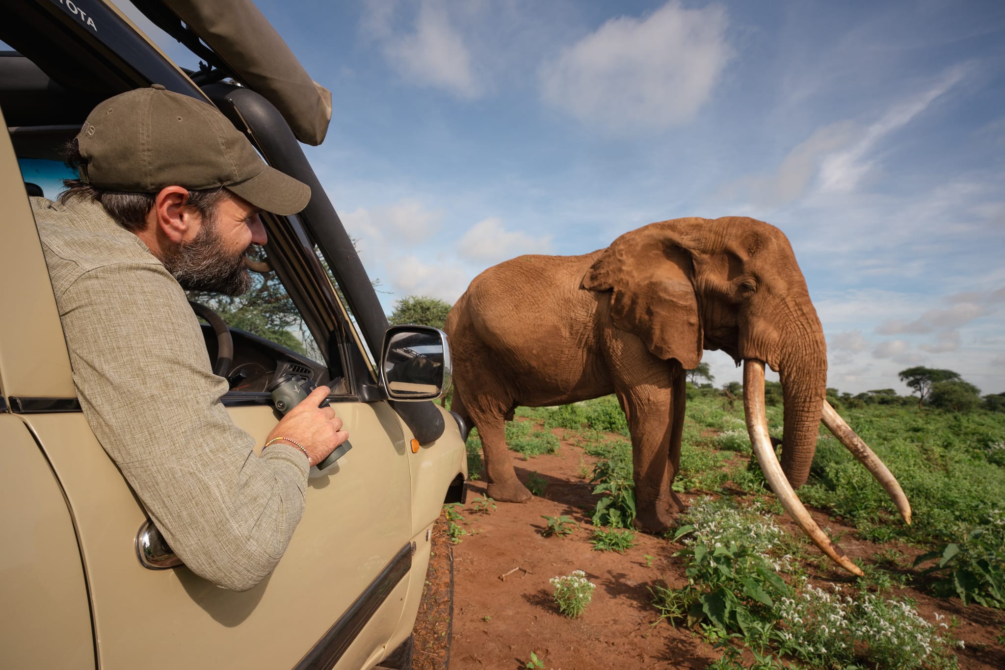 Austin photographing a super tusker from the cruiser window, Amboseli