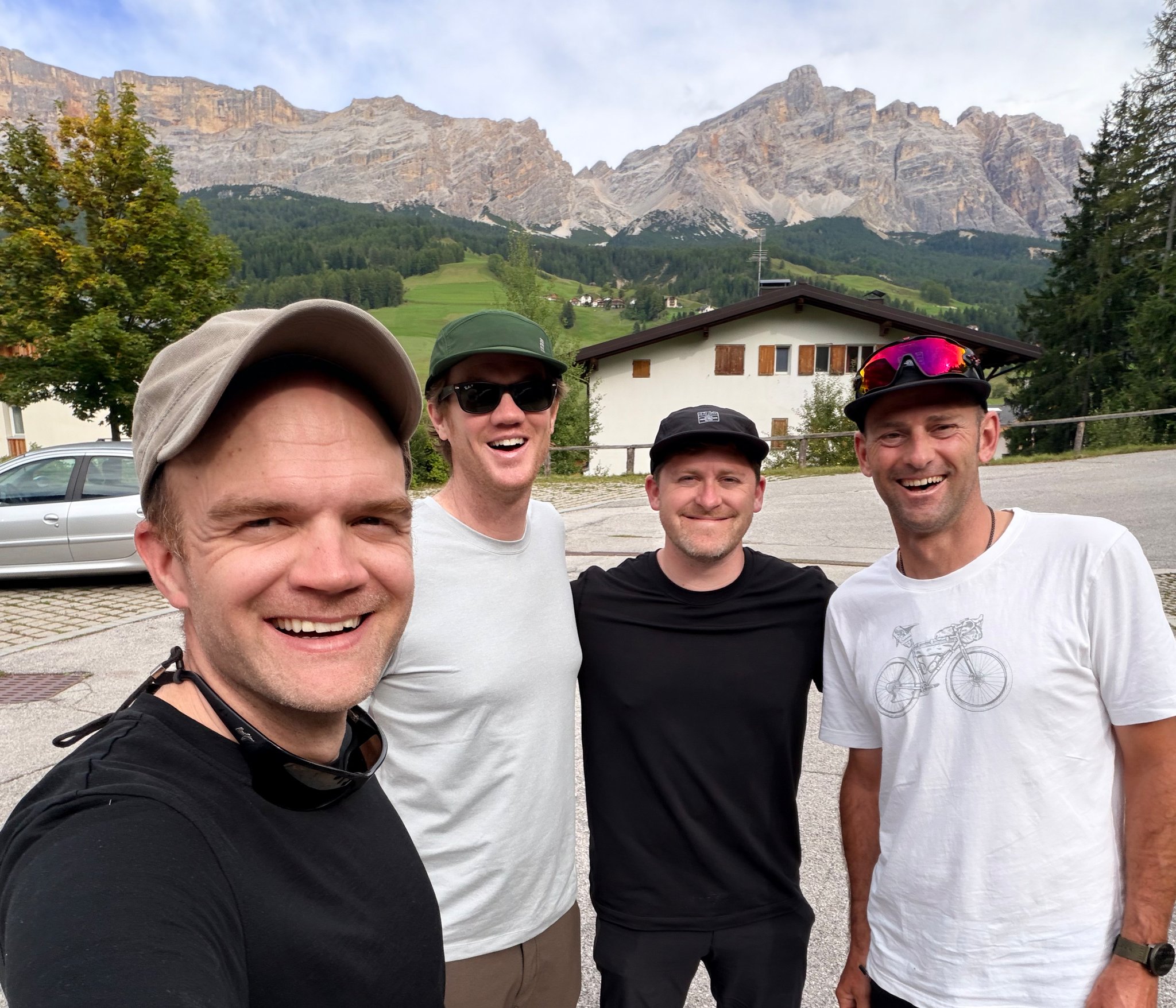 The four of us at the end of the trip, the Dolomites rising behind the village