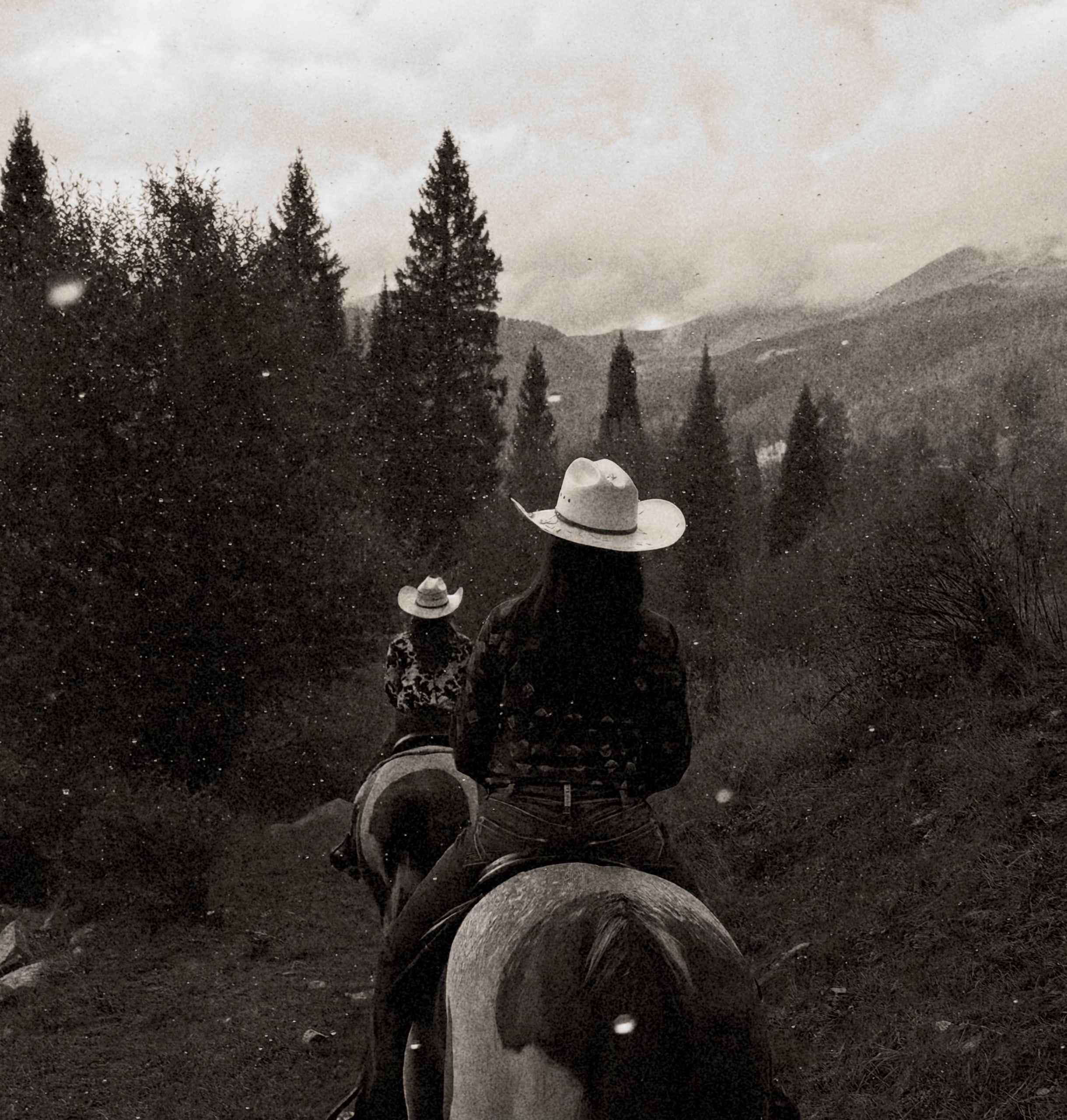 Sophia and Brooklynn riding through an afternoon rainstorm in the high Rockies